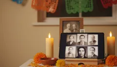 Ofrenda de Día de Muertos con velas, fotos familiares y papel picado tradicional mexicano.